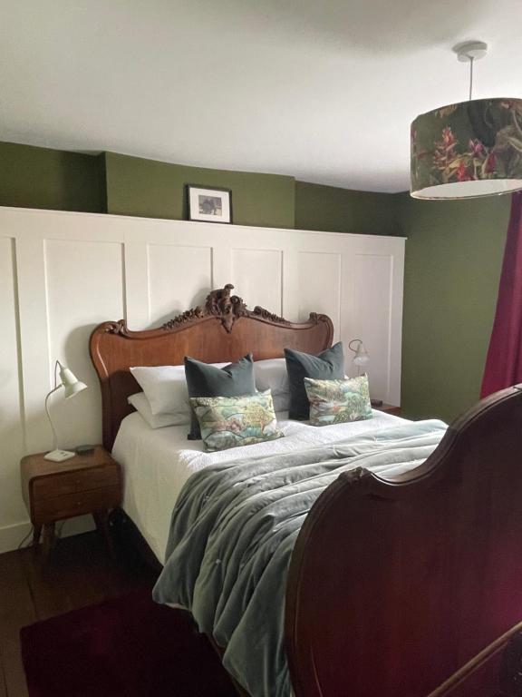 a bedroom with a large bed with green walls at Caretaker’s Cottage 