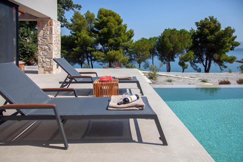 a patio with a table and chairs next to a swimming pool at Theros Estate in Amfilochía