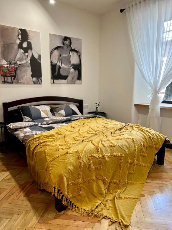 a bedroom with a bed with a yellow blanket at Art Apartment Glebova in Lviv