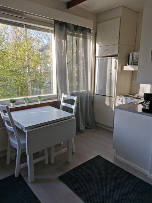 a kitchen with a table and chairs and a refrigerator at Ihana yksiö in Kokkola