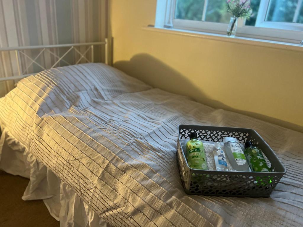 a basket of toiletries sitting on top of a bed at Single bed Parking Internet Coffee Garden Patio TV Quiet Close to main bus route B98 9NH in Beoley