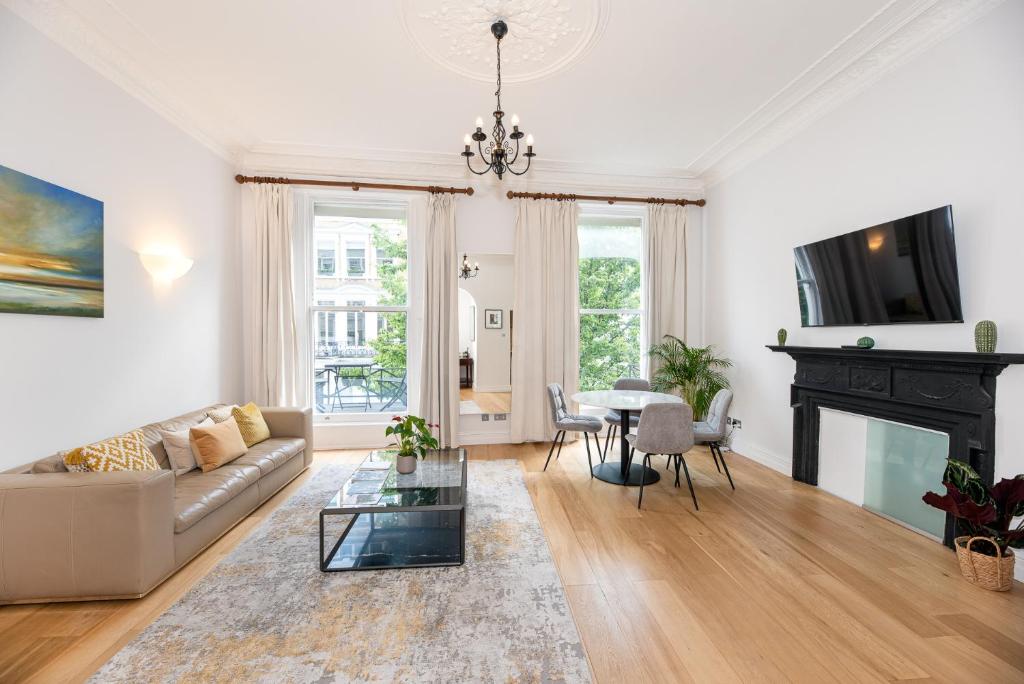 een woonkamer met een bank en een open haard bij 2-Bedroom Victorian Apartment in Kensington in Londen