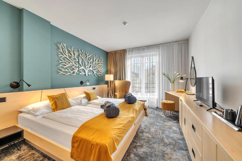 a bedroom with a large bed and a television at Spa Hotel Felicitas in Poděbrady
