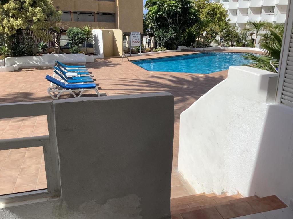 a pair of lounge chairs sitting next to a swimming pool at Piscina directa in Playa Fañabe