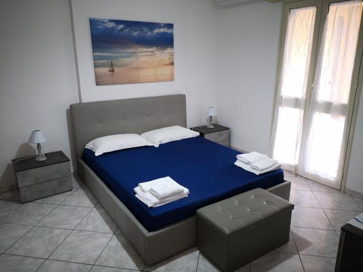 una camera da letto con letto con lenzuola blu e cuscini bianchi di The Sail Apartment - Marzamemi a Marzamemi