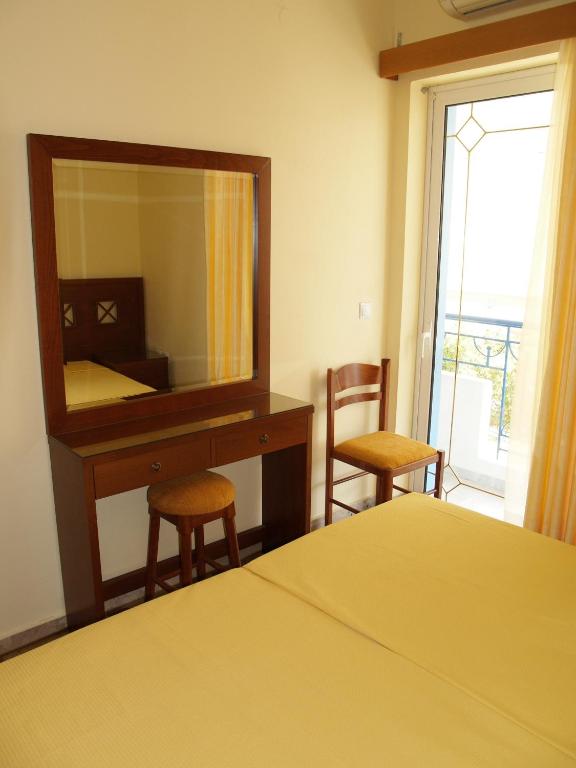 a bedroom with a bed and a dresser and a mirror at La Fontaine Apartments in Kandia