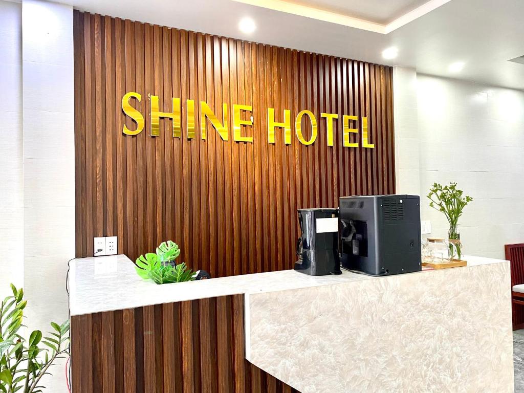 a shine hotel sign on a wooden wall at Shine Hotel in Hue