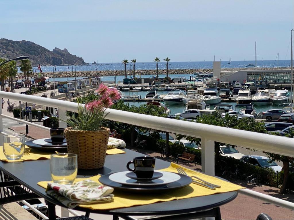 een tafel op een balkon met uitzicht op een jachthaven bij Les Orenetes in L'Estartit