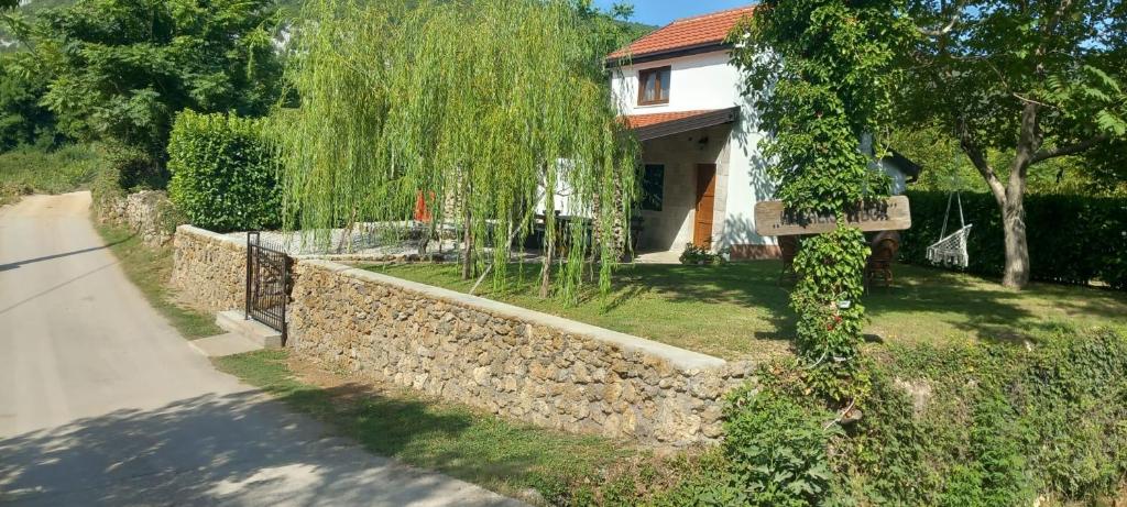 una casa con una pared de piedra y una valla en Kuća za odmor Buk, en Čapljina