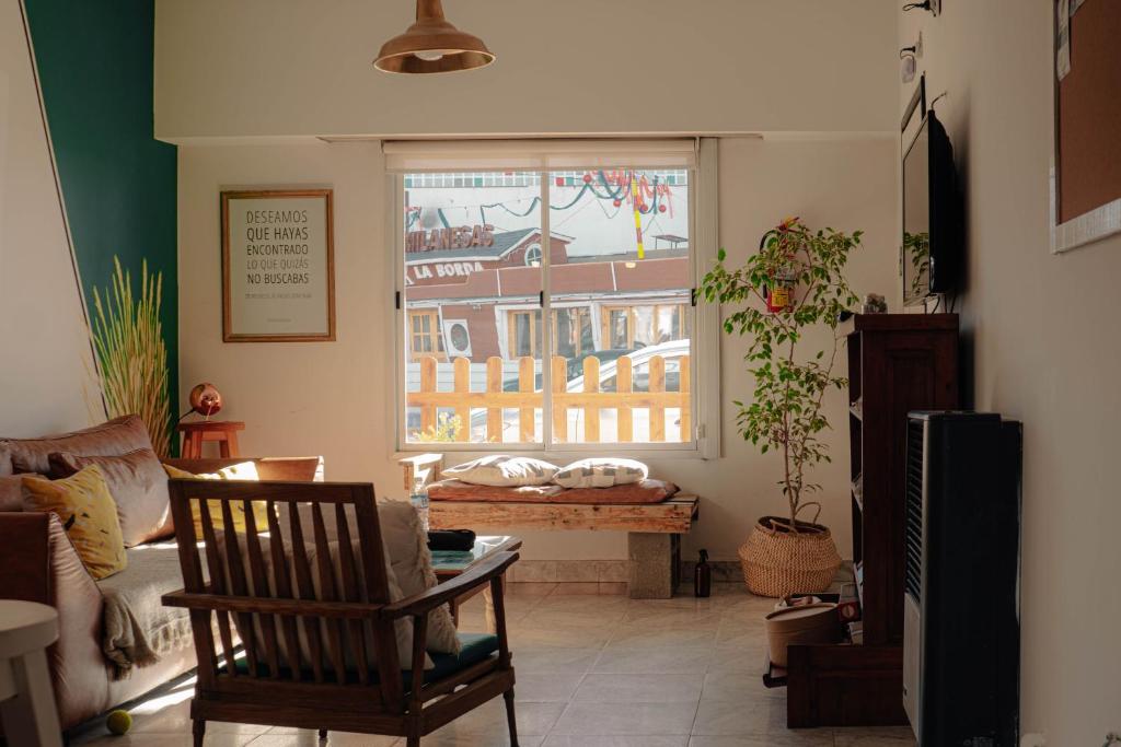 Chepatagonia Hostel & Experiences في بويرتو مادرين: غرفة معيشة مع نافذة مطلة على مبنى
