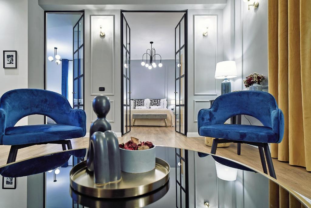 - un salon avec des chaises bleues et une table dans l'établissement LILIENBLUM CHIC Apartment ChicLife - Borgo Santa Caterina, à Bergame