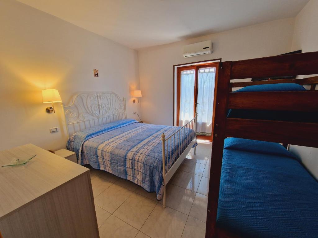 ein Schlafzimmer mit einem Bett und einem Etagenbett in der Unterkunft Il sasso bed & breakfast in Sasso di Castalda