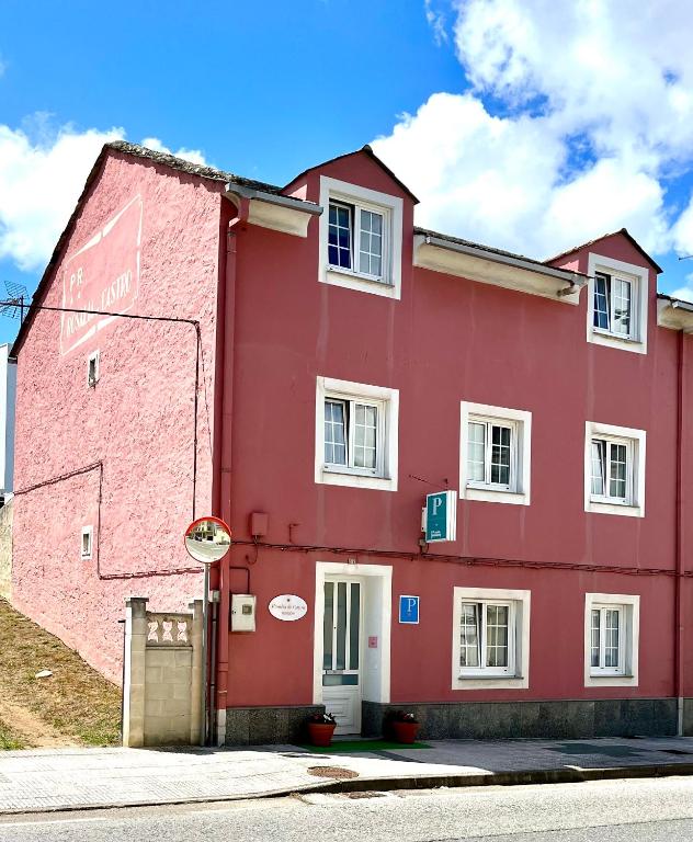 a red building on the side of a street at Pension Rosalia de Castro in Foz