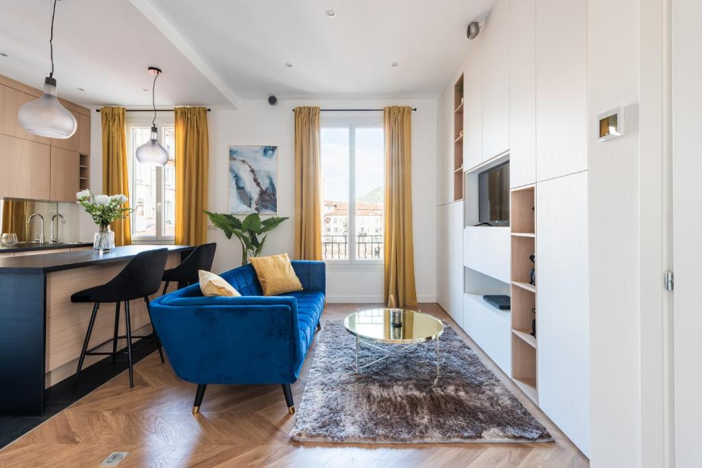 un salon avec un canapé bleu et une cuisine dans l'établissement 3 SMOLETT - Appartement 2 pieces LUXE - Climatisé - ACROPOLIS, à Nice