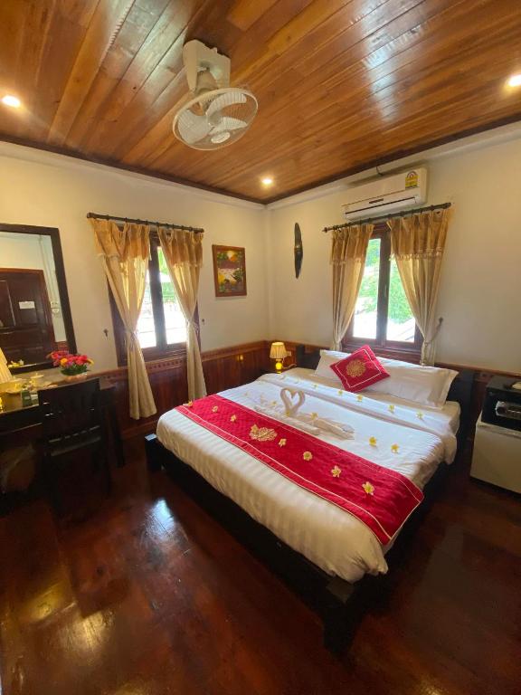 a bedroom with a large bed with a wooden ceiling at Golden Lotus Boutique Hotel in Luang Prabang