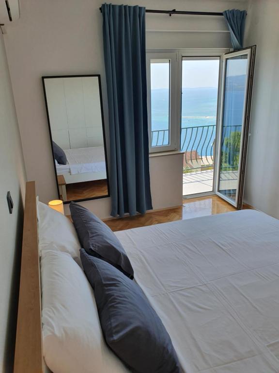 a bedroom with a large bed and a mirror at Apartman Oneum in Omiš