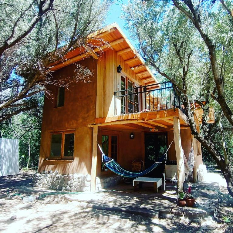 a house with a hammock in front of it at Casa corazon in San Marcos Sierras