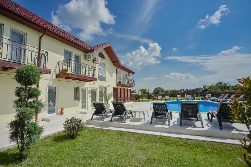 a patio with chairs and a swimming pool at Pensiunea Ovidiu in Crisan