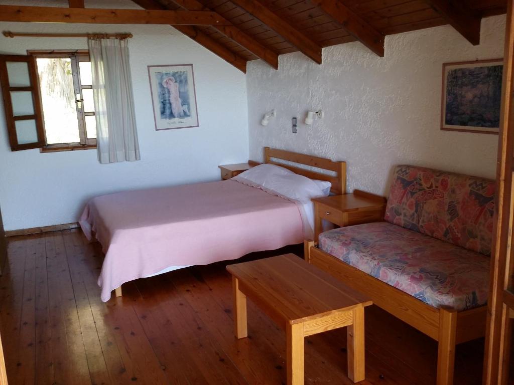 a bedroom with a bed and a couch and a chair at 2bedrooms Cottage 1 in Palaiochóra