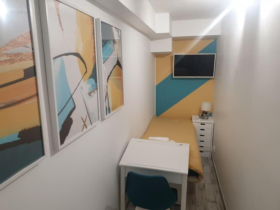 Kleines Zimmer mit einem Schreibtisch und Gemälden an der Wand in der Unterkunft L'art et Deco RerC-n104-A6-A10 in Brétigny-sur-Orge