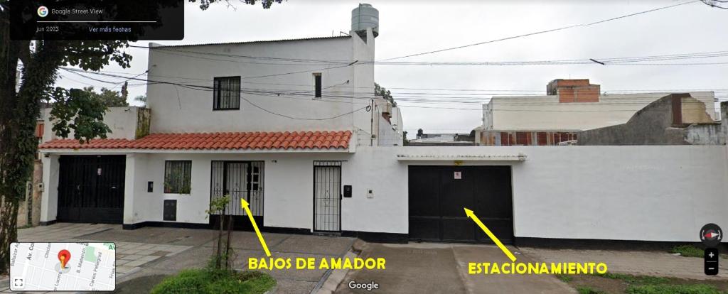 a white house with two garage doors with yellow arrows at BAJOS de AMADOR in San Miguel de Tucumán