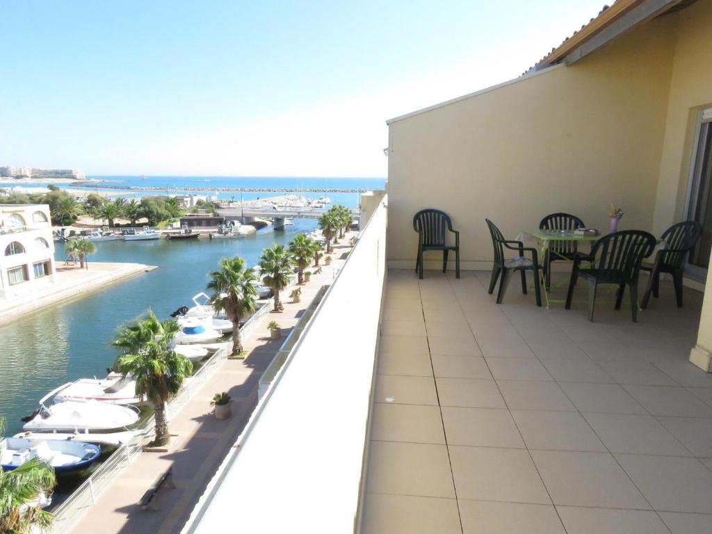 d'un balcon avec des tables, des chaises et des bateaux dans l'eau. dans l'établissement T2 cabine 35m² dernier étage, terrasse, parking - FR-1-472-136, à Sète