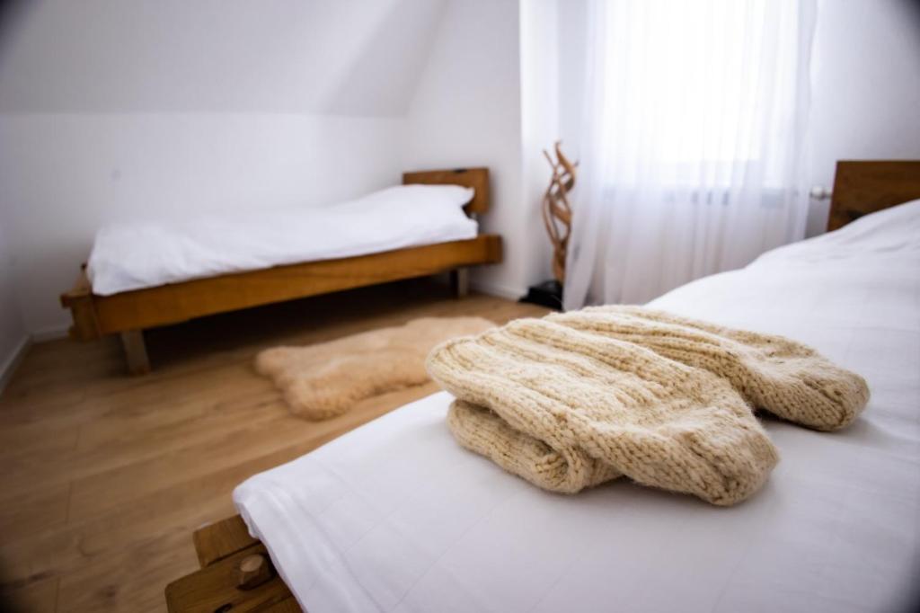 una camera con due letti con lenzuola bianche di Topli kutak Golija a Novi Pazar