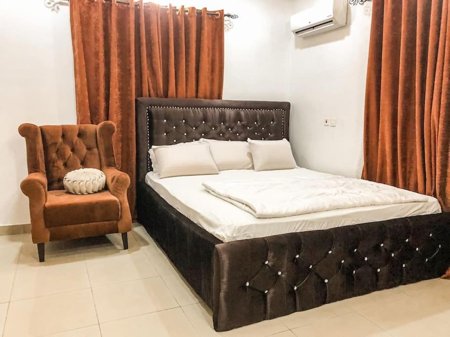 un letto e una sedia in una stanza di Cozy 1 bedroom apartment in Abuja ad Abuja