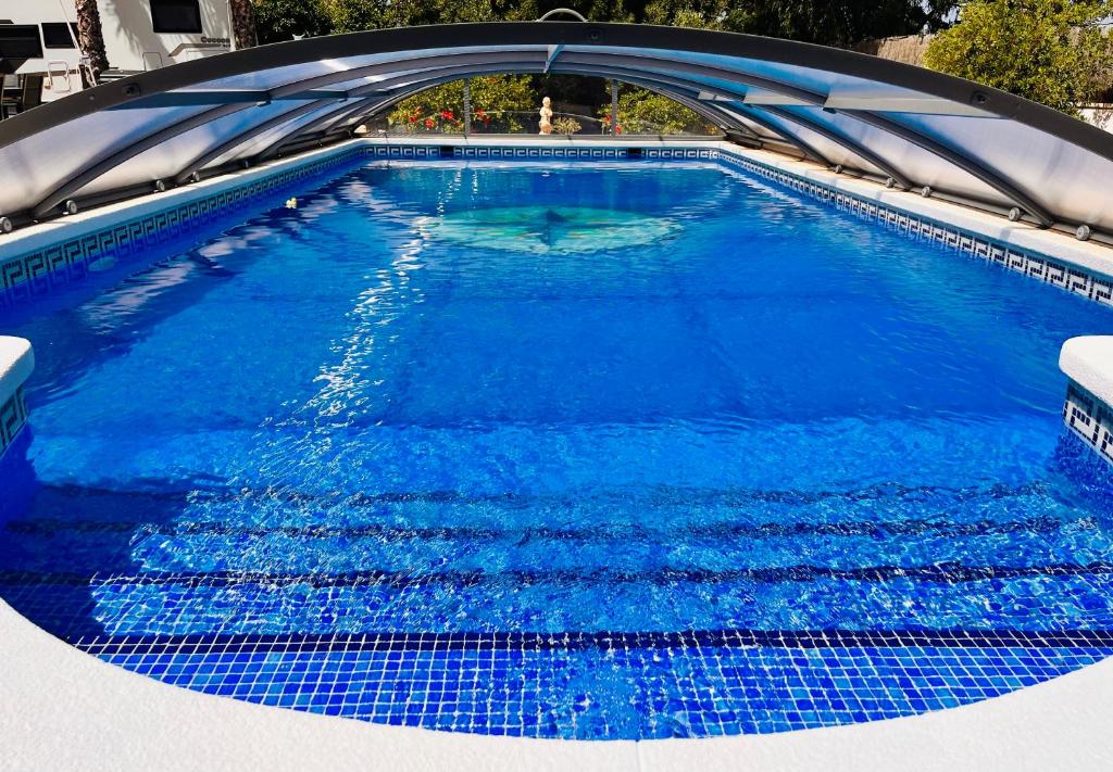 uma piscina com água azul e uma ponte em Sport2Relax Sportsflat Cabeço d'Or em Busot