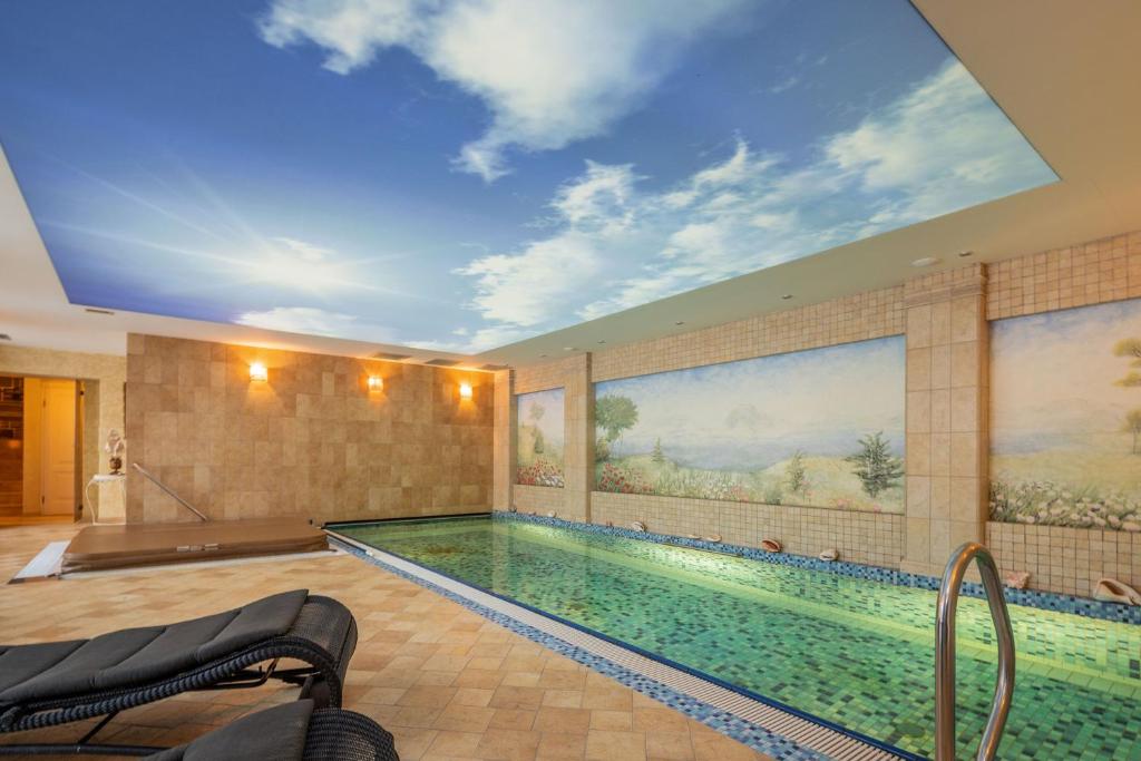 a large swimming pool with a ceiling with a sky at Amber dream Karkle in Karklė