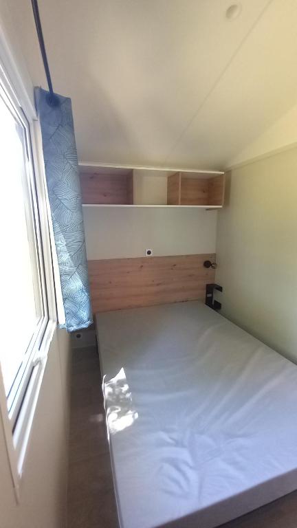niewielka sypialnia z łóżkiem i oknem w obiekcie L'ARDECHO MODULO w mieście Saint-Lager-Bressac