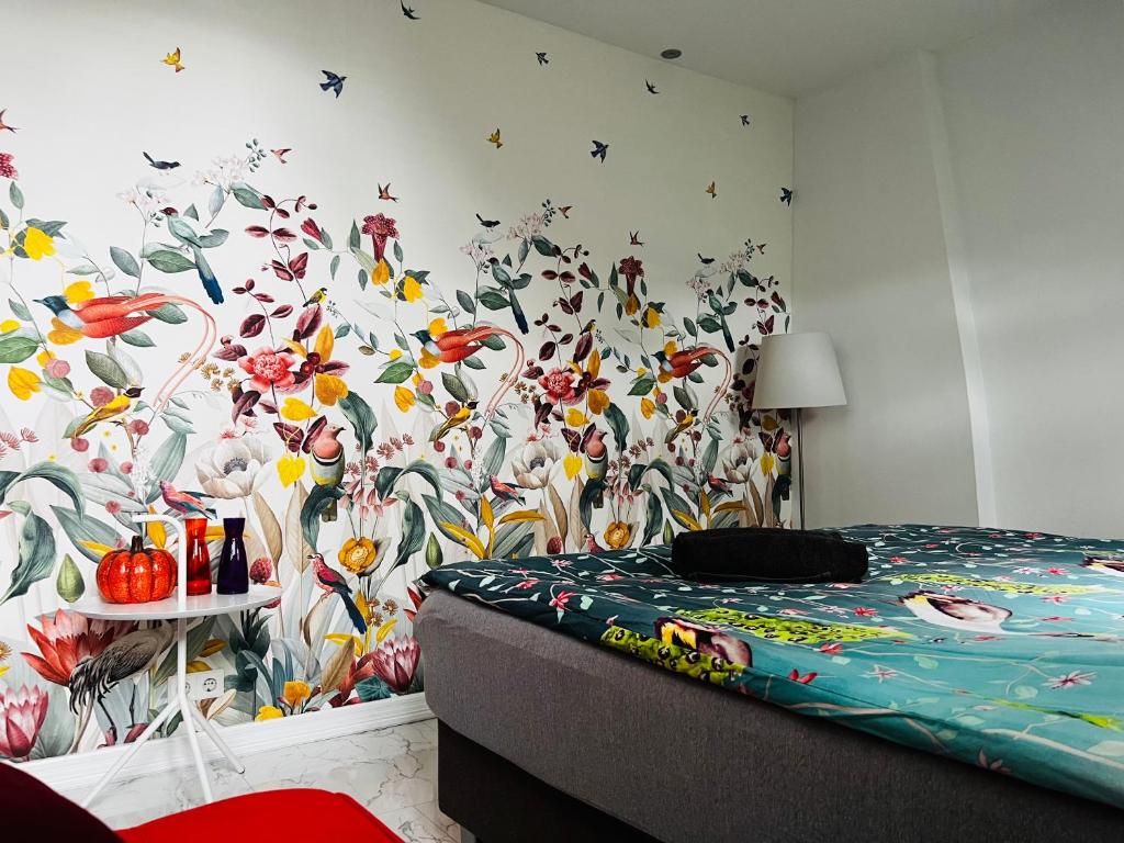 1 dormitorio con un mural de flores en la pared en Chez Hélène Luxury BNB, en Maastricht