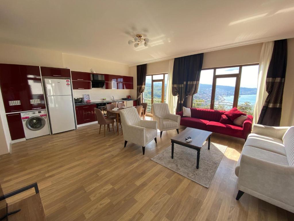 a living room with a red couch and a kitchen at Trabzon Mountain View in Yomra
