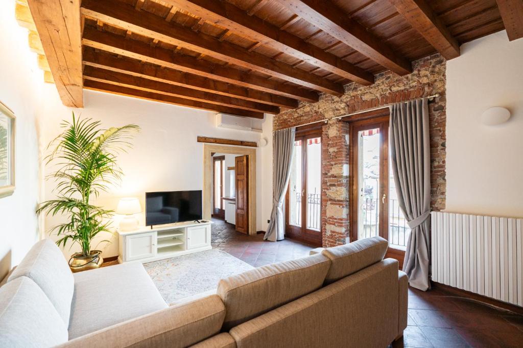 sala de estar con sofá y TV en Domus Verona - Residenza Merici, en Verona