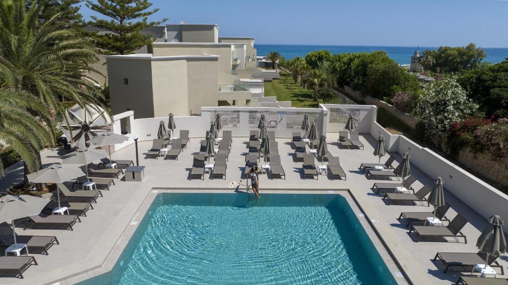 odkryty basen z leżakami i ośrodek w obiekcie Vantaris Luxury Beach Resort w mieście Georgioupolis