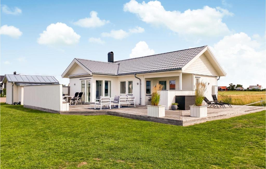 une maison blanche avec une terrasse dans un champ dans l'établissement Amazing Home In Falkenberg With Kitchen, à Falkenberg
