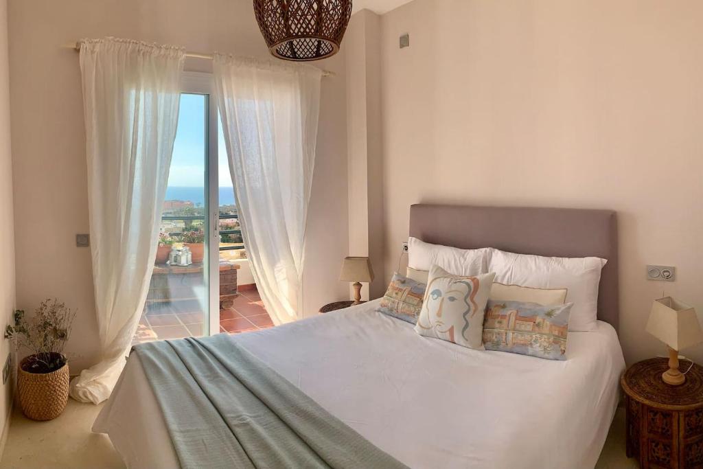 um quarto com uma cama e vista para o oceano em Los Jardines Del Mar em Manilva