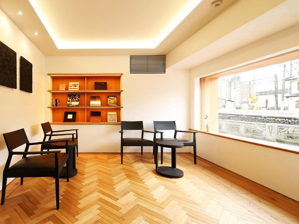 a room with chairs and a table and a window at Ichidaya in Toyooka