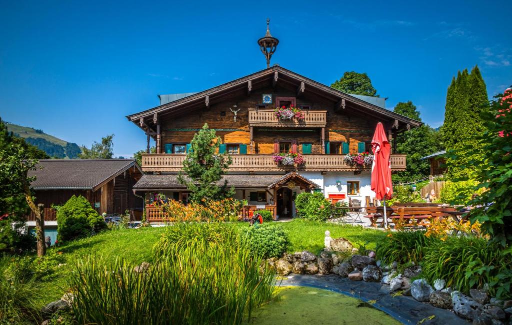 una gran casa de madera con un río frente a ella en Ferienhof Millinghof, en Leogang