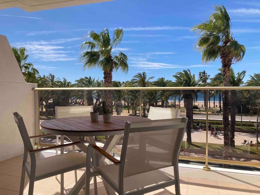 uma mesa e cadeiras numa varanda com palmeiras em Apartament amb vistes al mar! em Salou