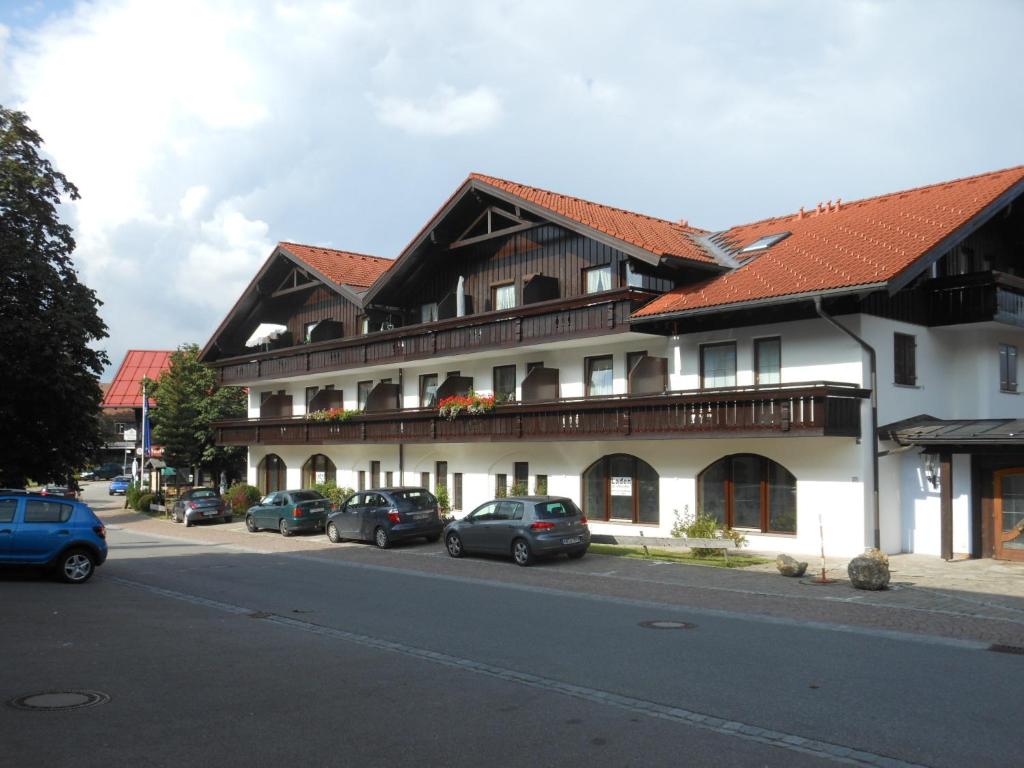 un gran edificio con coches estacionados frente a él en Allgäustüble, en Steibis