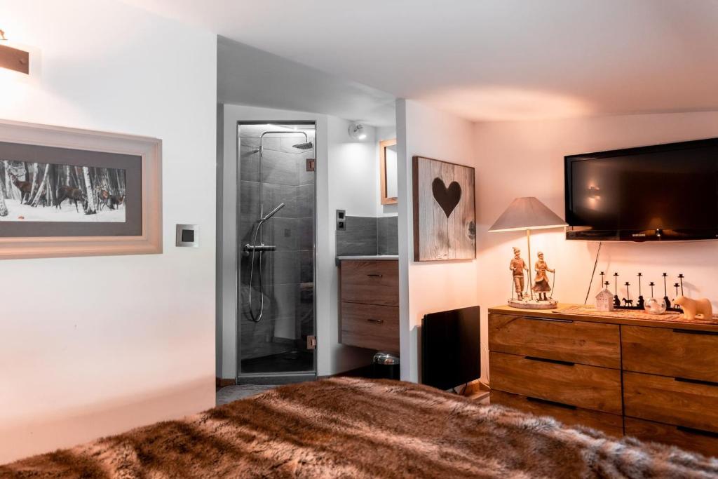 a bedroom with a large bed and a tv on the wall at IMMODREAMS - Chalet Le Grand Paradis - Avoriaz in Avoriaz