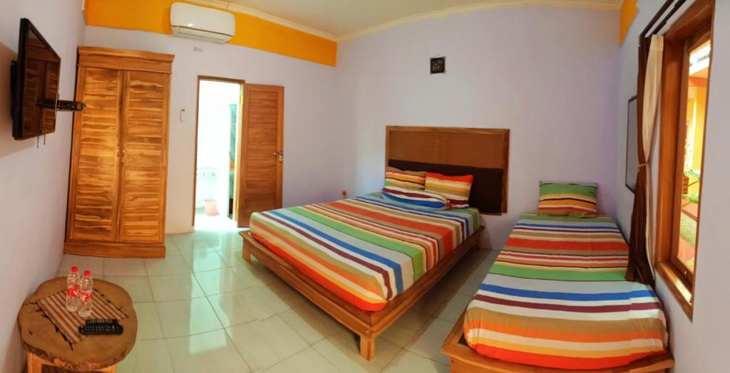 a bedroom with two beds and a table at Latansa Homestay in Banyuwangi