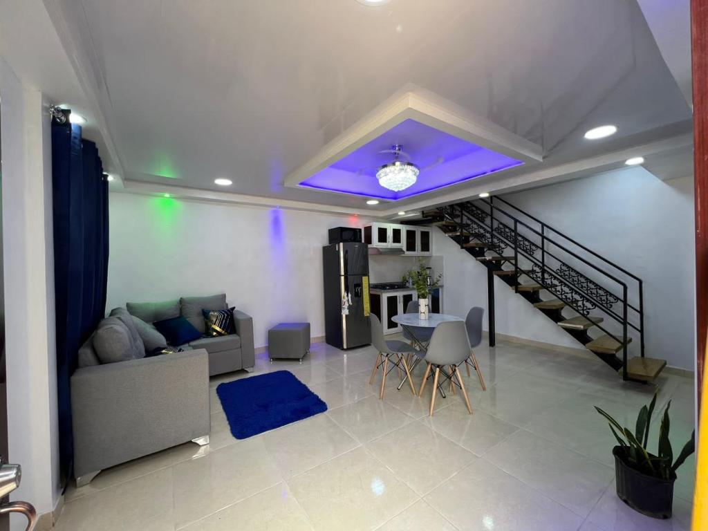 a living room with a couch and a staircase at Alojamiento paulino in Santiago de los Caballeros