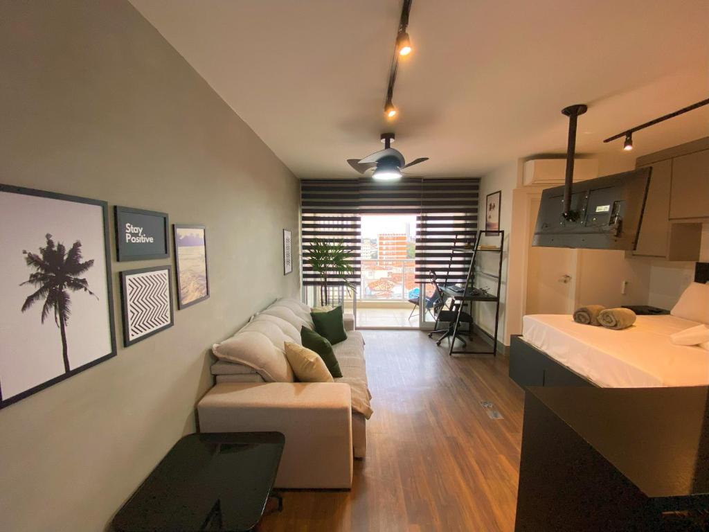 uma sala de estar com um sofá e uma mesa em Studio a 100m Bosque, Centro e Cambuí- Home Office, Piscina, Sauna, Jacuzzi, Fitness em Campinas
