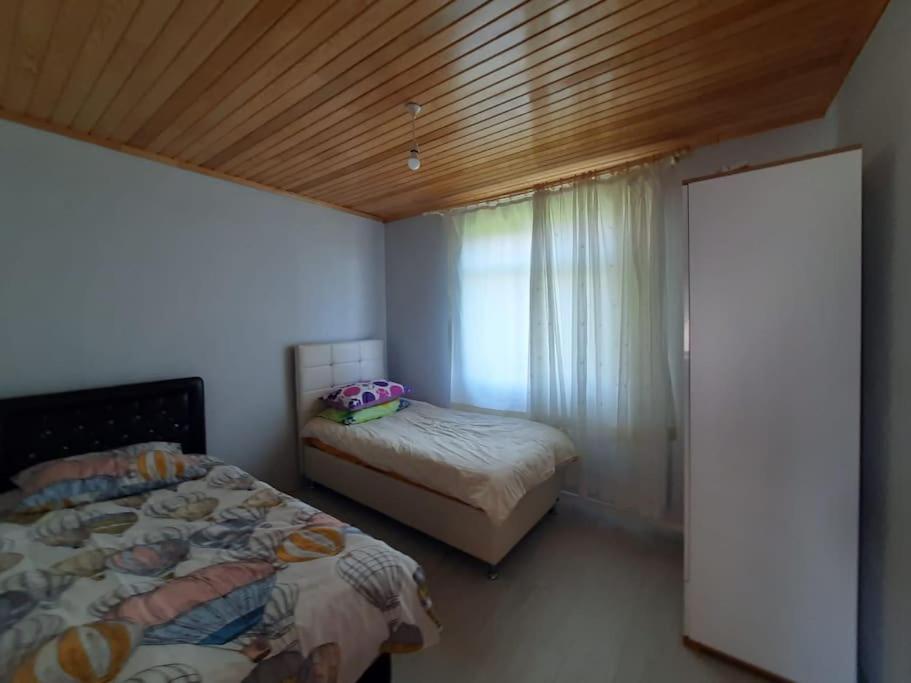 Schlafzimmer mit einem Bett und einem Fenster sowie einem Bett sidx sidx sidx in der Unterkunft Yomra Köy Evi in Yomra