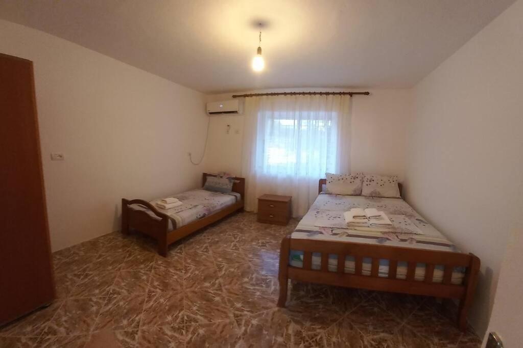 een slaapkamer met 2 bedden en een raam erin bij Λευκό σπίτι in Ksamil