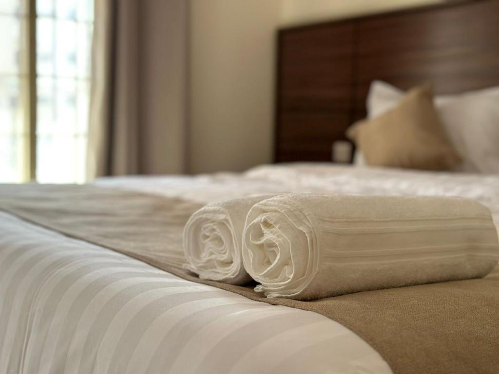 a bed with two white towels on it at mnarat al madina in Al Madinah