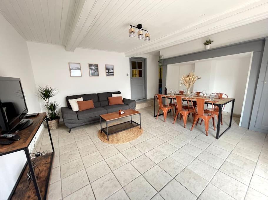 ein Wohnzimmer mit einem Sofa und einem Tisch in der Unterkunft Maison Opaline in Berck-sur-Mer