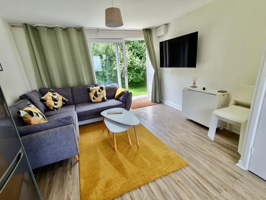 a living room with a couch and a table at Beach Woods Coastal Path chalet in Pembrokeshire
